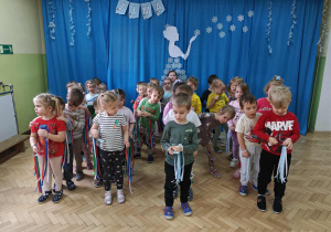 Dzieci przenoszą piórka na łyżce.