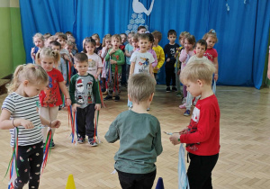 Dzieci przenoszą piórka na łyżce.