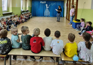 Dzieci słuchają wiersza o zimie, czytanego przez prowadzącą.