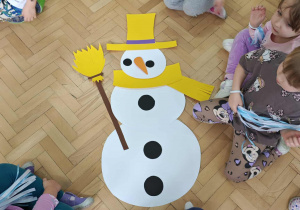 Dzieci układają postać bałwanka z elementów.