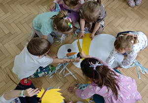 Dzieci układają postać bałwanka z elementów.