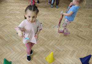 Dzieci przenoszą piórka na łyżce.