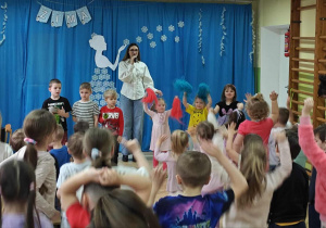 Dzieci uczestniczą w koncercie: grają na instrumentach, tańczą z pomponami.