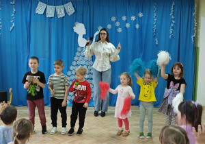 Dzieci uczestniczą w koncercie: grają na instrumentach, tańczą z pomponami.