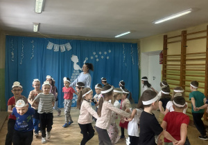 Dzieci biorą udział w zabawie ruchowej.