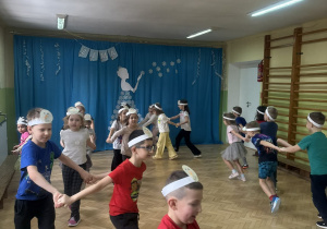 Dzieci biorą udział w zabawie ruchowej.