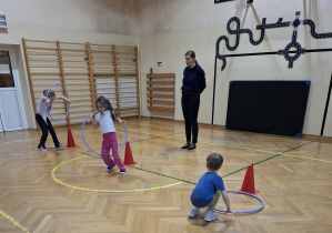 Dzieci wykonują ćwiczenia podczas zajęć ruchowych.