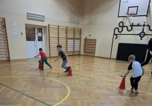 Dzieci wykonują ćwiczenia podczas zajęć ruchowych.