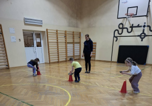 Dzieci wykonują ćwiczenia podczas zajęć ruchowych.