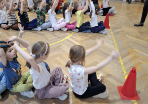 Dzieci wykonują ćwiczenia podczas zajęć ruchowych.