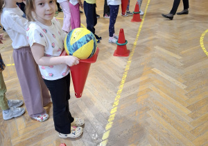 Dzieci wykonują ćwiczenia podczas zajęć ruchowych.