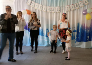 Przedstawiciele grupy odbierają nagrodę i dyplomy za udział w przeglądzie tanecznym.