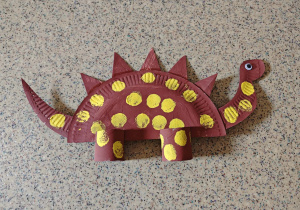 Eko dinozaur z papieru i papierowych rolek.