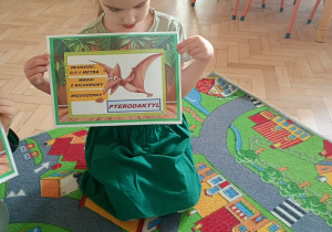 Dziecko pozuje do zdjęcia z pamiątkowym dyplomem.