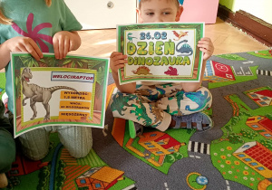 Dzieci pozują do zdjęcia z pamiątkowymi dyplomami.