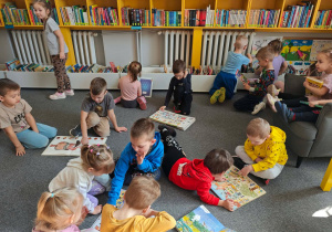 Dzieci poszukują wiosny w dostępnym księgozbiorze.