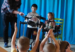 Dzieci grają na elektrycznej perkusji.