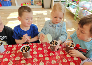 Dzieci podlewają zasadzoną cebulkę.