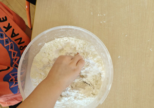 Dziecko poszukuje ukrytych przedmiotów w pojemniku z solą.
