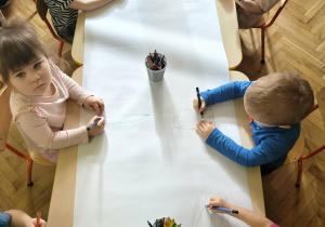 Dzieci wspólnie rysują.