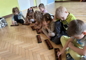Dzieci pracują na liczydle soroban.