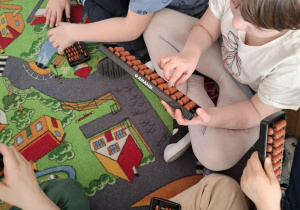 Dzieci dodają i odejmują na liczydłach soroban.