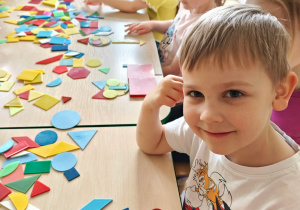 Dzieci układają figury geometryczne w dowolny sposób, tworząc z nich ciekawe obrazki.