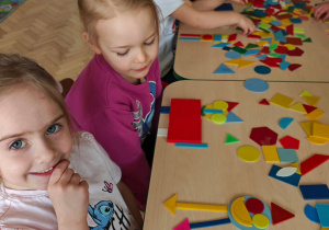 Dzieci układają figury geometryczne w dowolny sposób, tworząc z nich ciekawe obrazki.