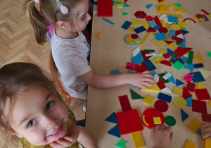 Dzieci układają figury geometryczne w dowolny sposób, tworząc z nich ciekawe obrazki.