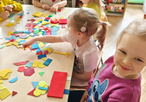 Dzieci układają figury geometryczne w dowolny sposób, tworząc z nich ciekawe obrazki.