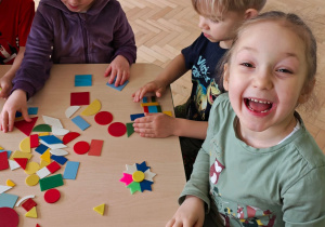 Dzieci układają figury geometryczne w dowolny sposób, tworząc z nich ciekawe obrazki.