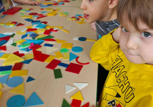 Dzieci układają figury geometryczne w dowolny sposób, tworząc z nich ciekawe obrazki.