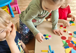 Dzieci układają figury geometryczne w dowolny sposób, tworząc z nich ciekawe obrazki.