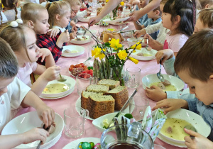 Dzieci jedzą wielkanocne śniadanie.