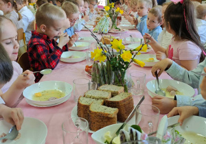 Dzieci jedzą wielkanocne śniadanie.