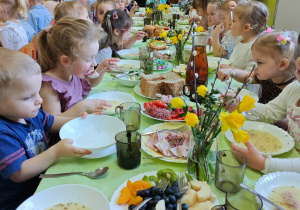 Dzieci jedzą wielkanocne śniadanie.