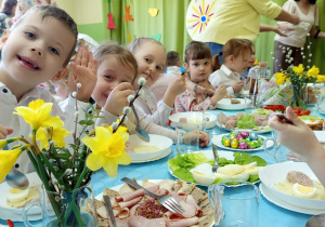 Dzieci jedzą wielkanocne śniadanie.