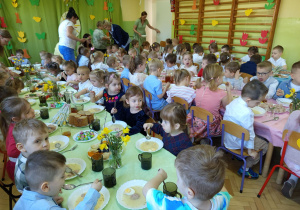 Dzieci jedzą wielkanocne śniadanie.