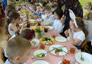 Dzieci jedzą wielkanocne śniadanie.
