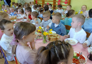 Dzieci jedzą wielkanocne śniadanie.