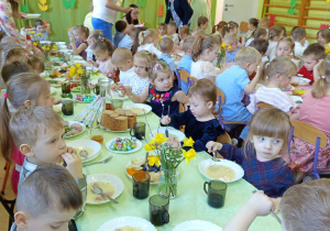 Dzieci jedzą wielkanocne śniadanie.