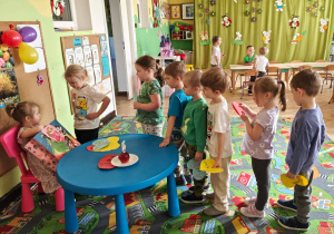 Dzieci wręczają Adzie laurki i składają życzenia.