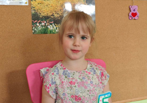 Dziewczynka siedzi przy urodzinowym stoliku.