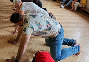 Rodzice tworzą most, pod którym przedostają się dzieci.