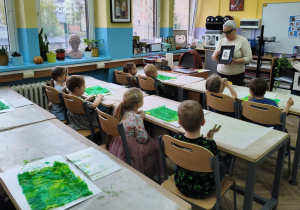 Dzieci siedzą w ławkach szkolnych