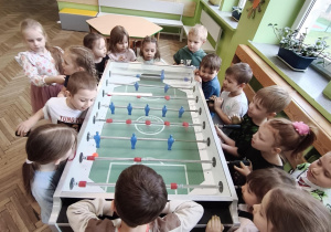 Dzieci przy stole do gry w piłkarzyki
