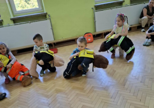 Dzieci ćwiczą na misiach sposób zachowania przy zadławieniu.