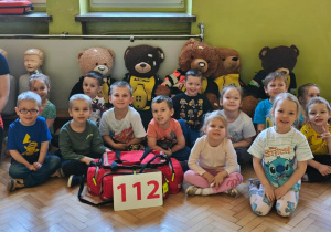 Dzieci pozują do zdjęcia z ratownikiem i misiami - pacjentami.