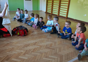 Ratownik prezentuje kolejny element z zawartości torby ratownika - chustę.
