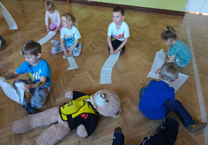 Dzieci zwijają bandaże.
